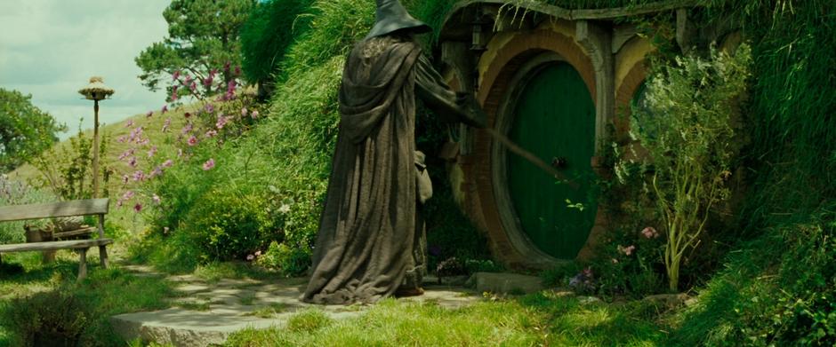 Gandalf knocks on the door to Bag End.