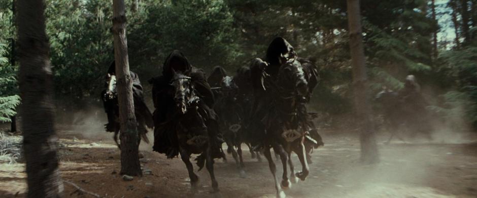 The Black Riders pursue Arwen and Frodo through the woods.