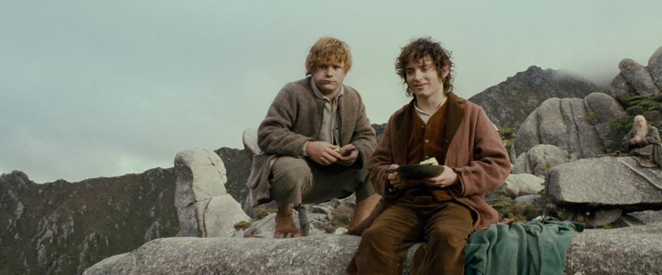 Sam and Frodo watch the other Hobbits practice swordplay with Boromir.