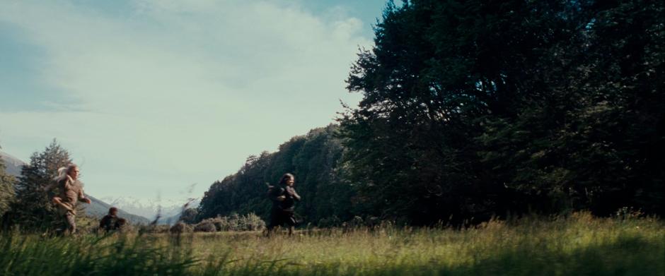 The Fellowship jogs into the edge of the Lothlórien forest.