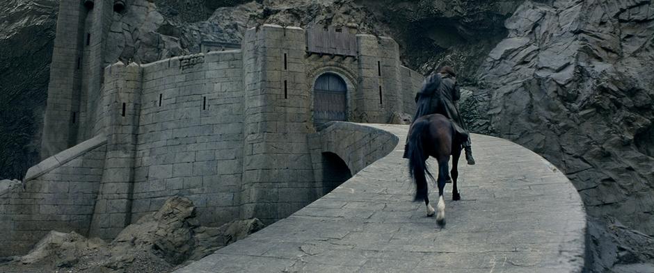 Aragorn rides up the ramp to the Helm's Deep gate.