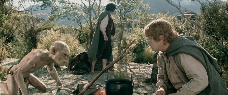 Sam and Gollum argue about Taters while Frodo looks into the distance.