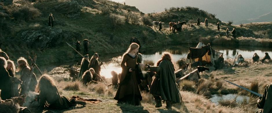 Eowyn passes Gimli while distributing soup to the refugees in the camp.