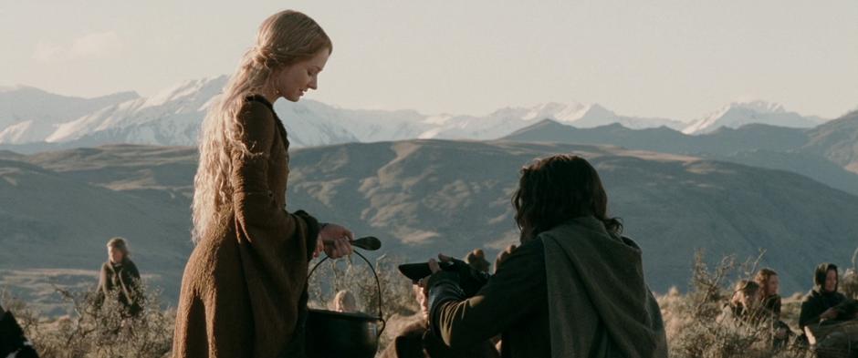 Eowyn serves soup to Aragorn while camping with the refugees.