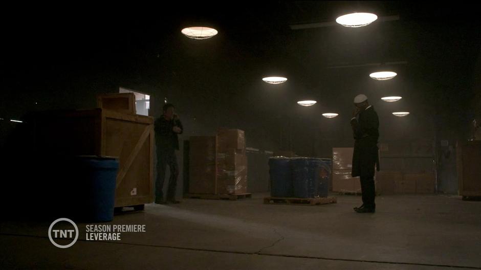 Nate and Hardison meet up in the warehouse.