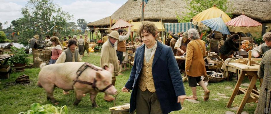 Bilbo walks through the market in Hobbiton. Does not appear in the first film, perhaps in the extended edition.