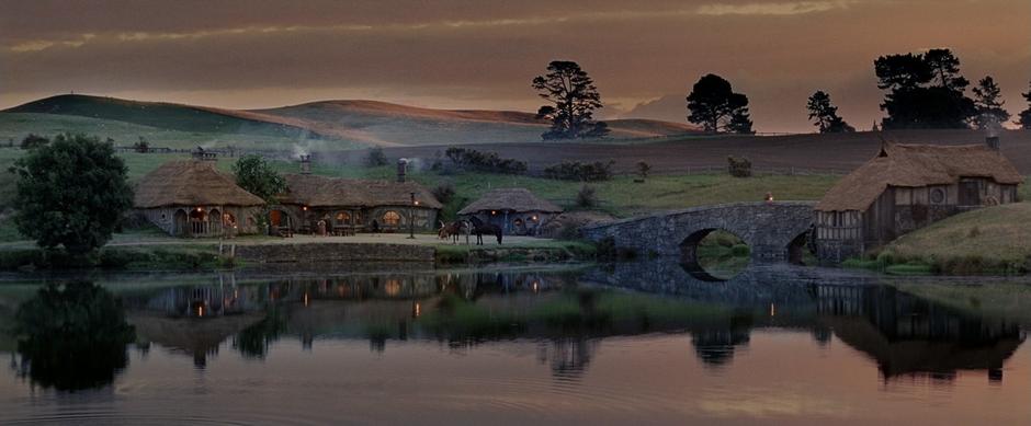 Nighttime establishing shot of Hobbiton taken over the lake after the Hobbits return from their journey.