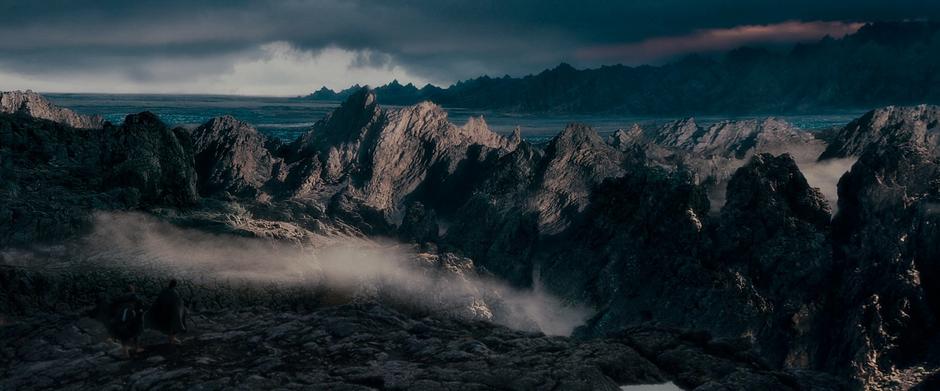 Sam & Frodo walk down into Emyn Muil with Mordor in the distance.