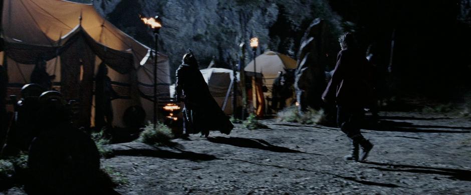 Aragorn walks to Theoden's tent where Elrond is waiting.
