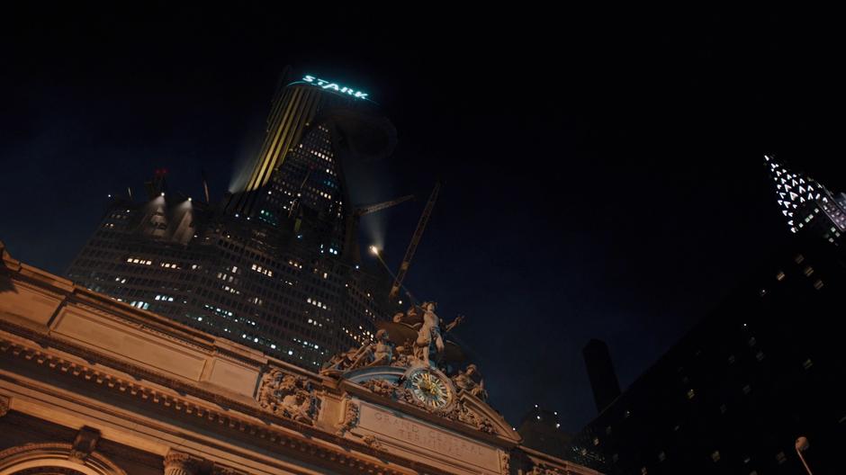 Iron Man flies over Grand Central Station up towards the under construction Stark Tower.