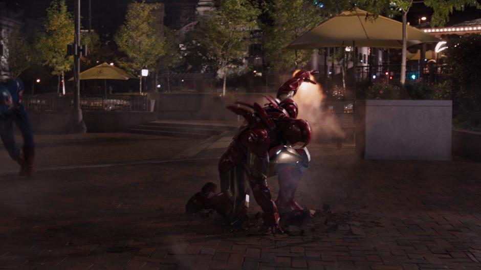 Iron Man lands in the plaza to help Captain America in the fight against Loki.