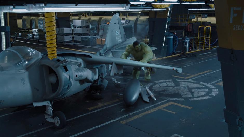 The Hulk starts to throw a fighter jet at Thor.