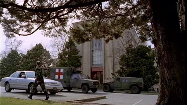 Air force vehicles drive past the front door to the hospital.