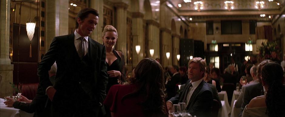 Bruce and his date approach Rachel and Harvey Dent's table.