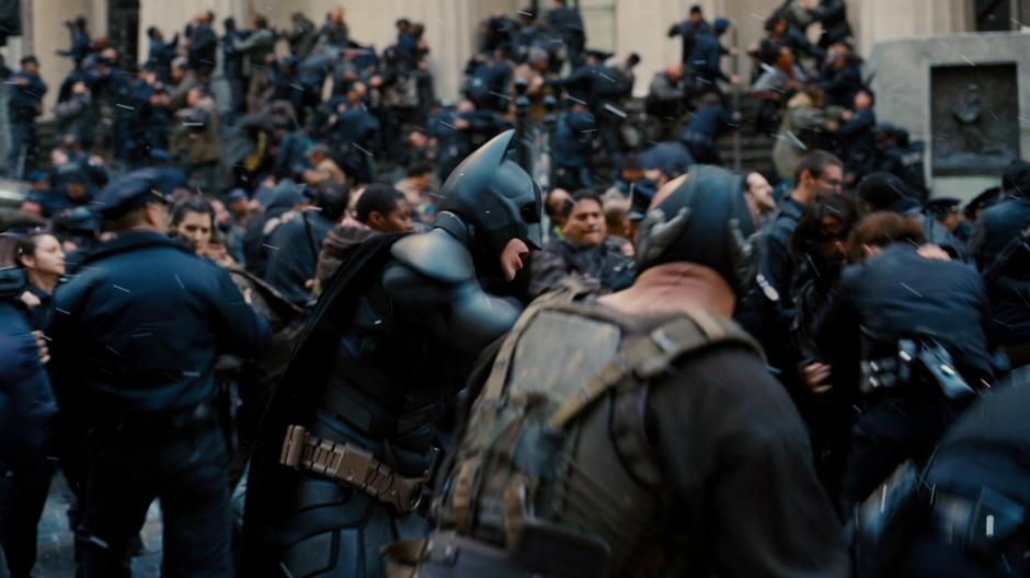 Bane and Batman brawl out front of city hall.