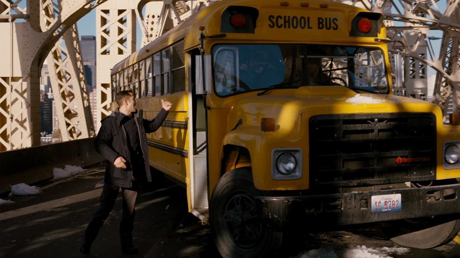 Blake leads the orphans off the school bus near the bridge barricade.