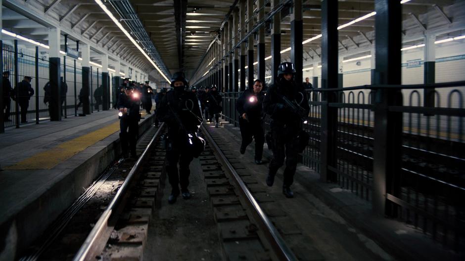 The Gotham PD storm the subway tunnels in force in search of Bane's hideout.