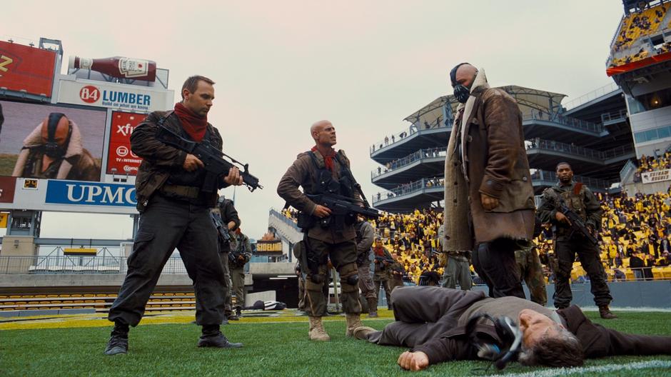 Bane and his thugs stand over the body of recently murdered Dr. Pavel.