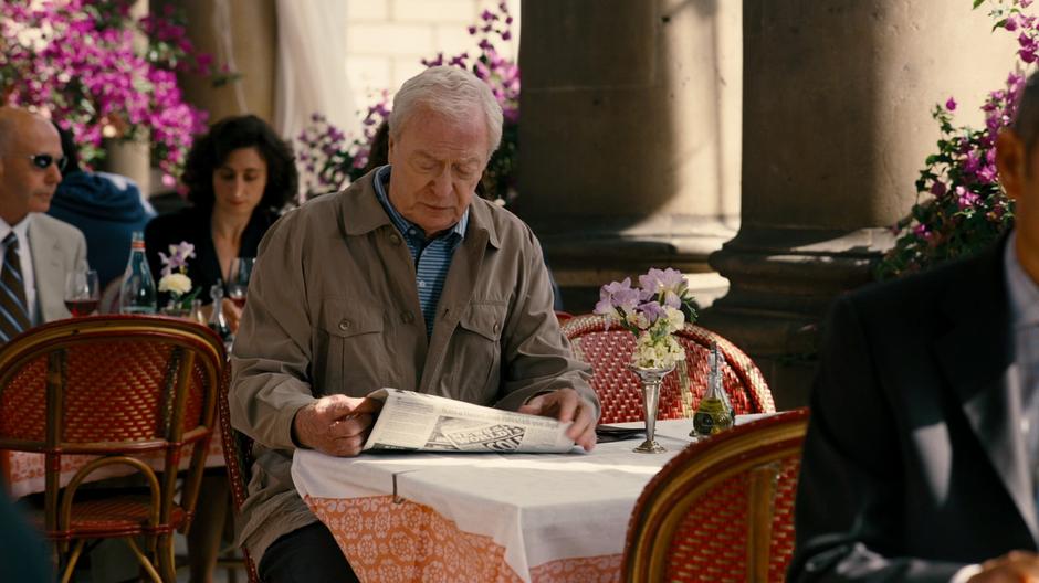 Alfred reads a newspaper at his usual table.