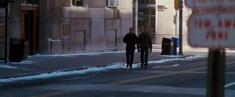 Blake and Captain Jones walk across the street after taking readings from the bomb truck.