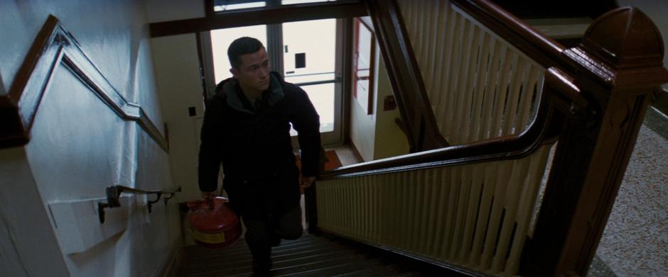 Blake walks up the stairs carrying some spare fuel.