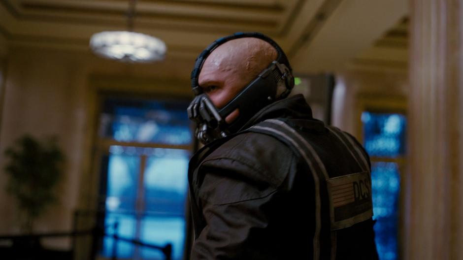 Bane prepares to enter the floor of the stock exchange.