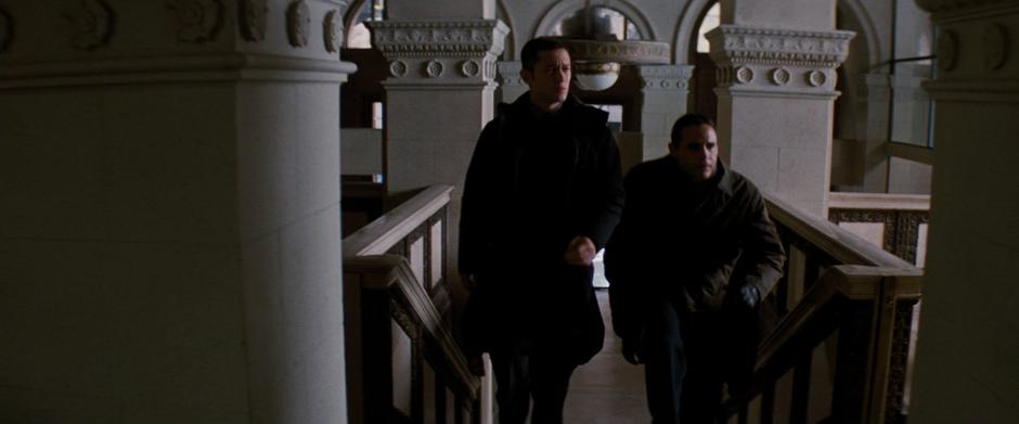 Blake and Captain Jones walk into where the Wayne Enterprises board is holed up.