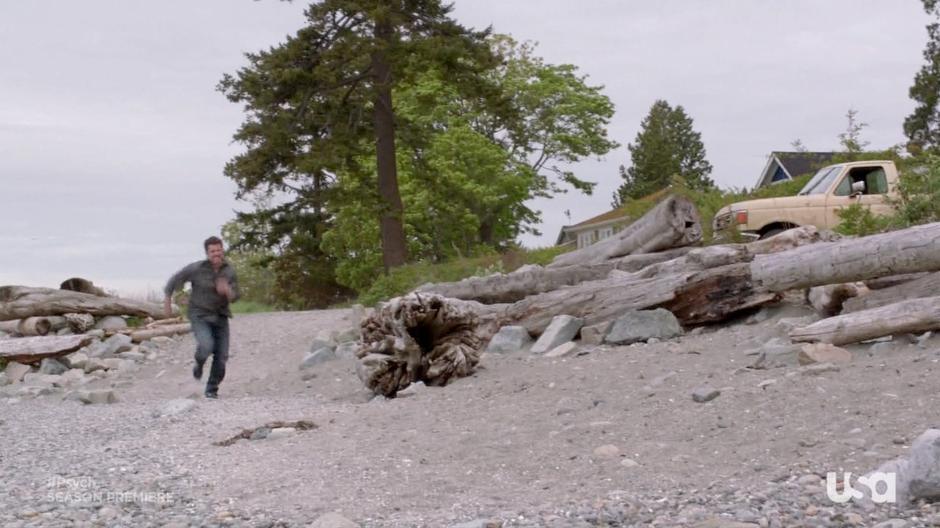 Shawn runs down the beach towards where Henry lies.