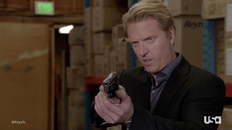 The FBI agent points his gun at Shawn and Gus.