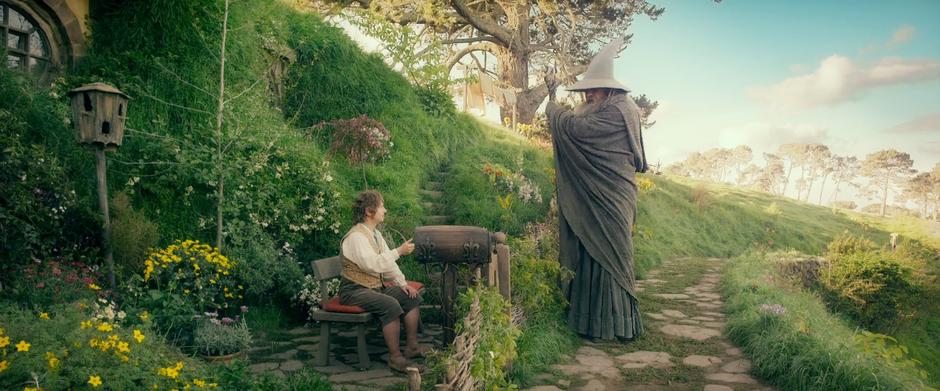 Gandalf greets Bilbo out front of Bag End.