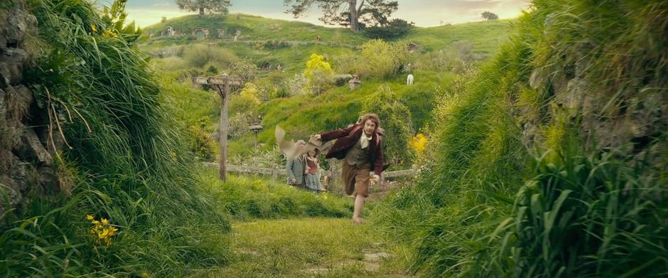 Bilbo runs through Hobbiton on his way to an adventure.