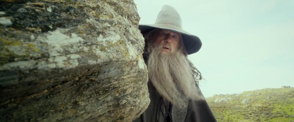 Gandalf looks around the side of a rock for the wargs.