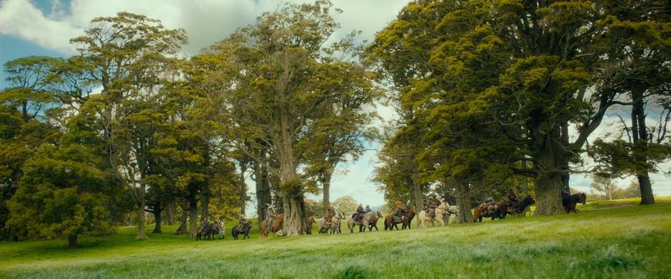 Gandalf, Bilbo, and the dwarves ride through the outskirts of Hobbiton.