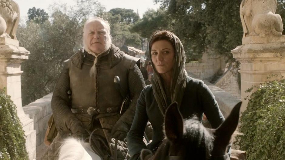 Catelyn and Ser Rodrik ride through the gate.