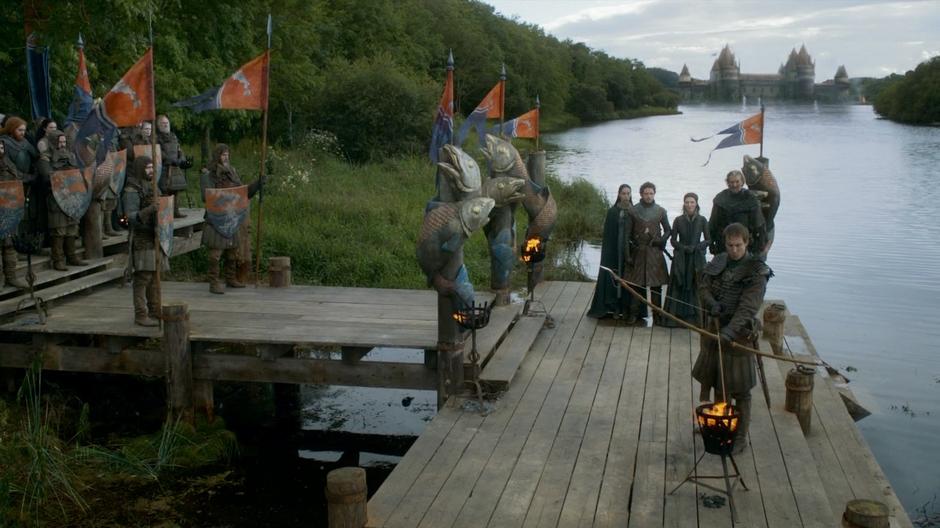 After missing with the first arrow, Edmure prepares to fire another while his family watches.