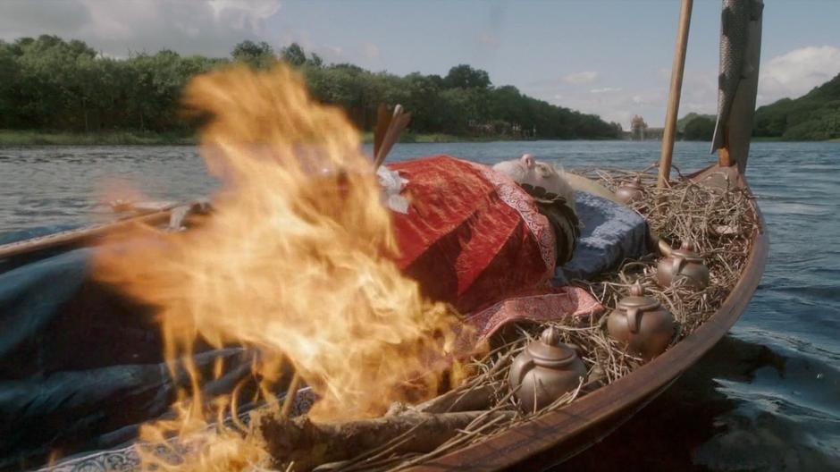 The arrow fired by Brynden the Blackfish lights the funeral boat on fire.