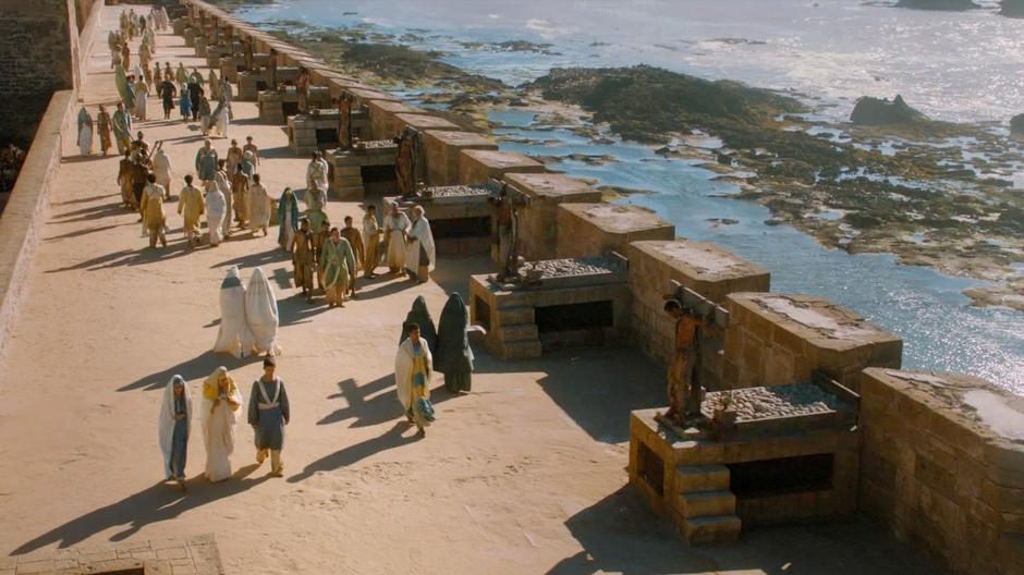Daenerys, Ser Jorah, and Barristan Selmy walk down the Walk while talking about how to win Westeros.