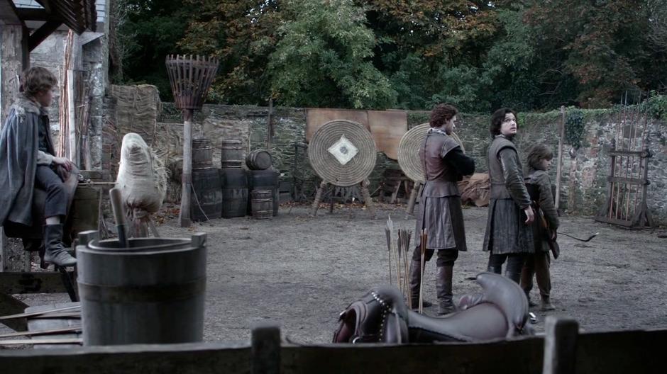 Jon Snow looks back at the balcony where Catelyn is watching the archery practice.