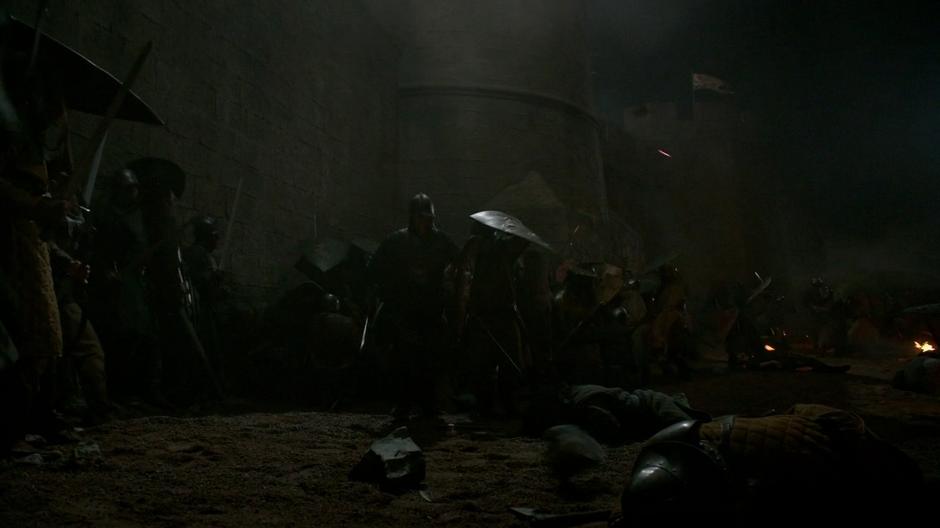Stannis's army hold up at the base of the wall while the city's defenders pelt them from above.