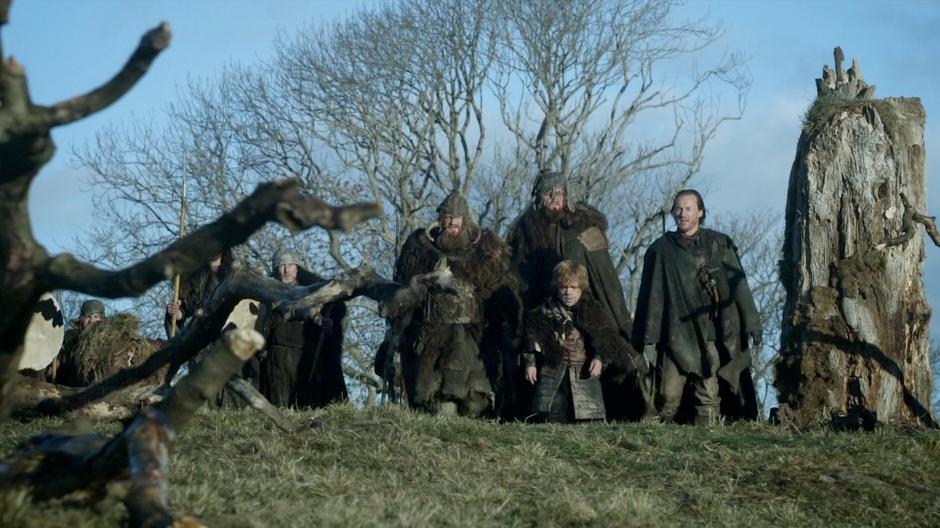 Tyrion and his mercenaries walk over a hill near the war camp.