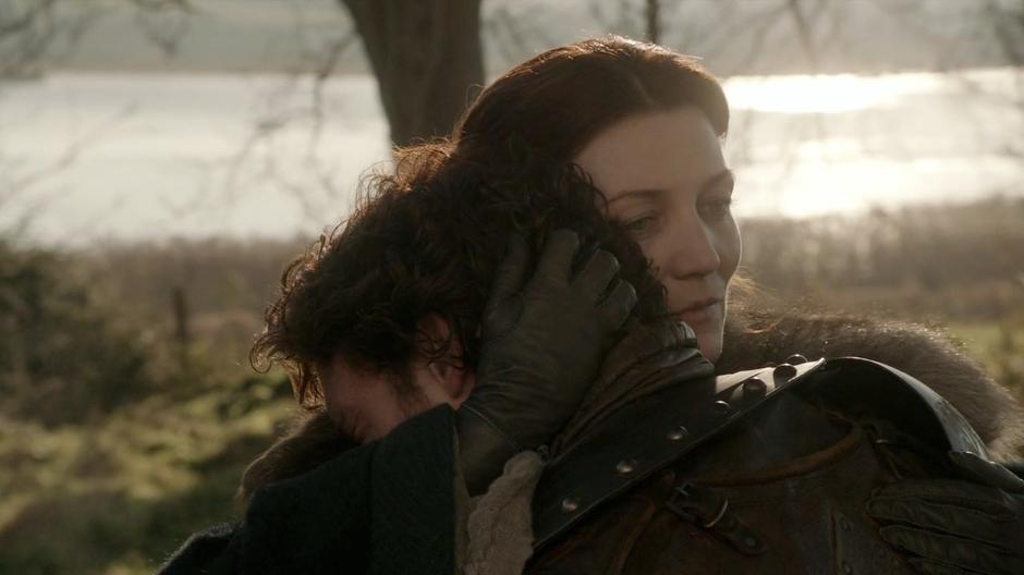 Catelyn and Robb hug in the woods by camp.