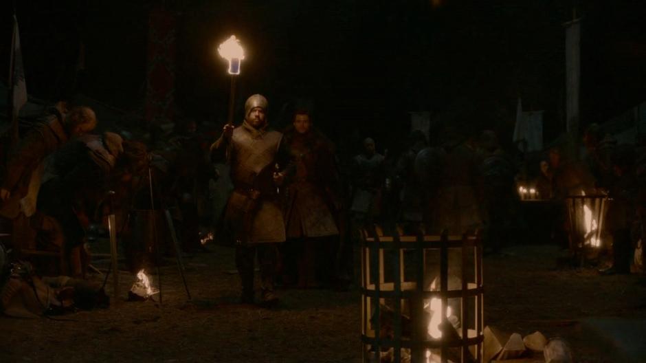 Robb walks through camp to Jaime's cell.
