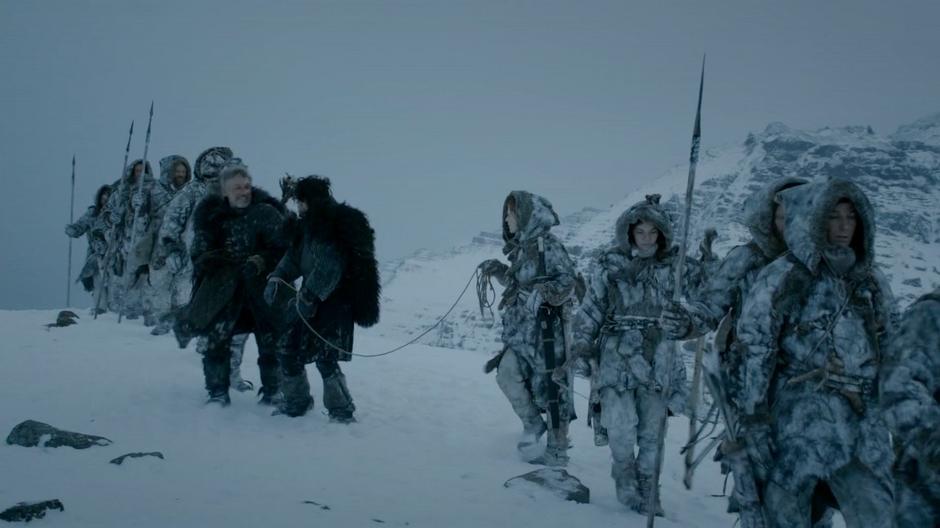 Ygritte leads Jon Snow and the Halfhand across a ridge.