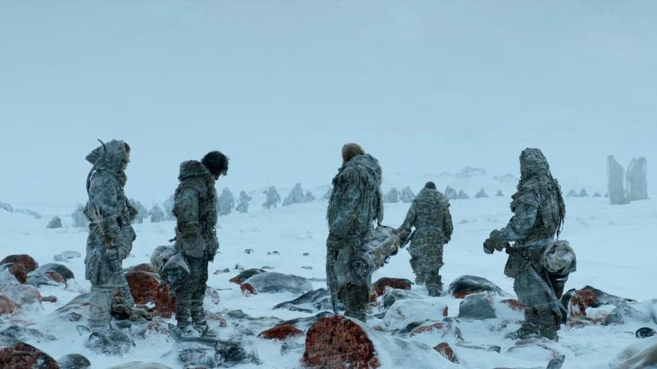 Mance, Jon Snow, and Ygritte stand over the severed horse heads while rest of the Wildlings come approach from behind.