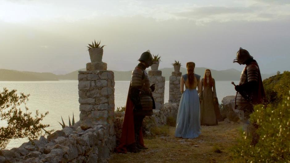 Margaery approaches Sansa who is being watched over by two guards.