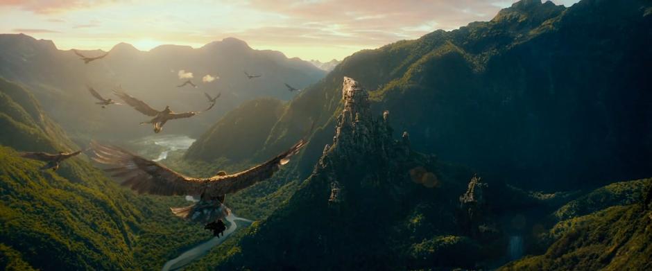 Eagles carrying Thorin's company fly down a valley toward the Carrock.