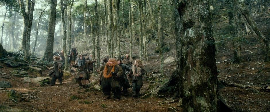 The dwarves run down a forested hillside while being chased by Beorn in bear form.