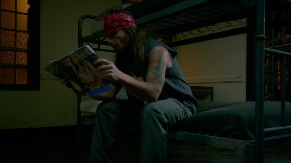 Julius reads a magazine in his prison cell.