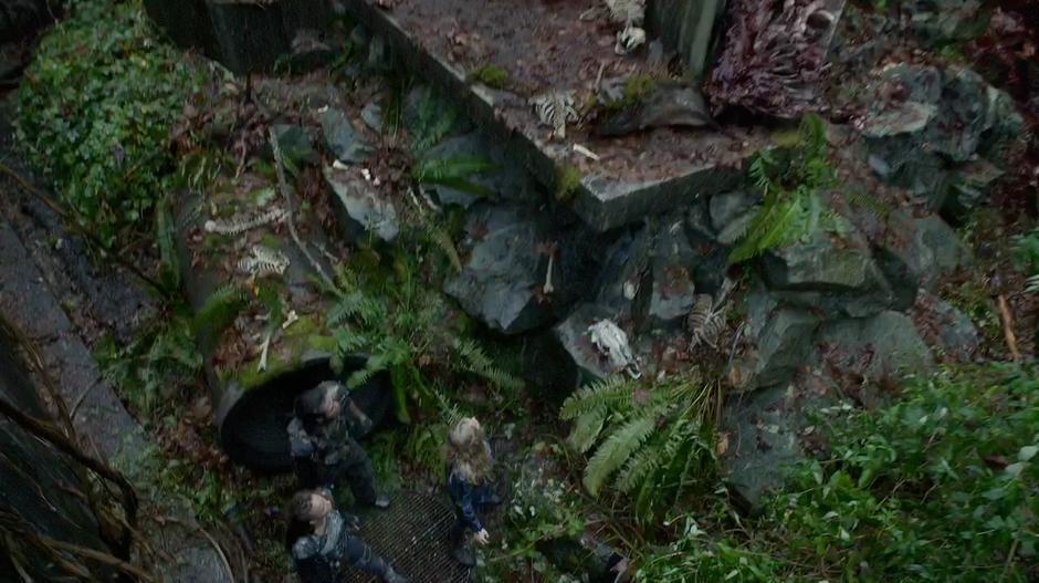 Clarke, Lexa, and the other Grounder look around the enclosure.