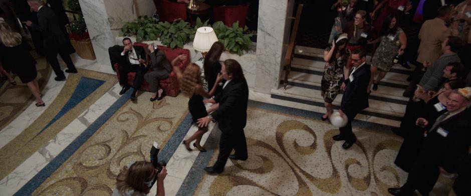 Happy escorts Tony and Maya through the hotel lobby.